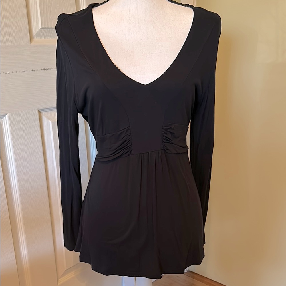 Black size XL runs small. Made in turkey. Long sleeves and self tie back.